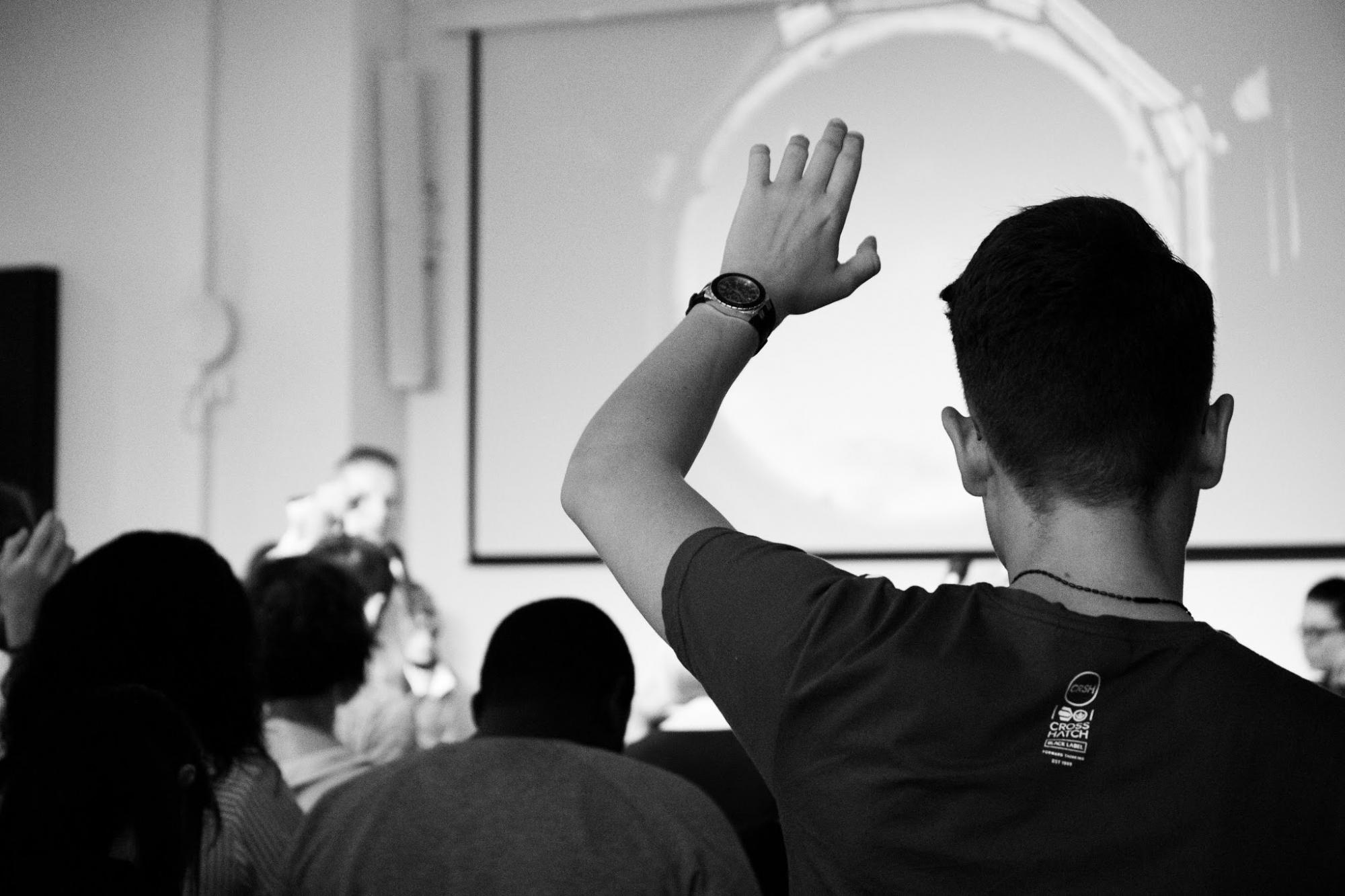 classroom setting with student raising hand