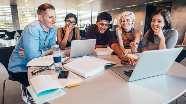 group of college students smiling and working