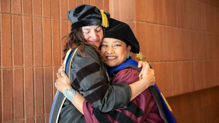 Brianne Arviso (right) hugs her doctoral studies adviser, Associate Professor Kristen Parrish (left) during the the Ira A. Fulton Schools of Engineering Spring 2022 Convocation ceremony at ASU. Photo by Erika Gronek/ASU